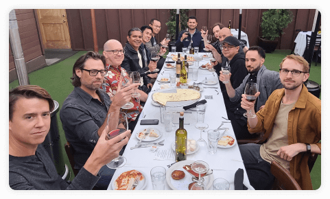 men holding up their glass at a table